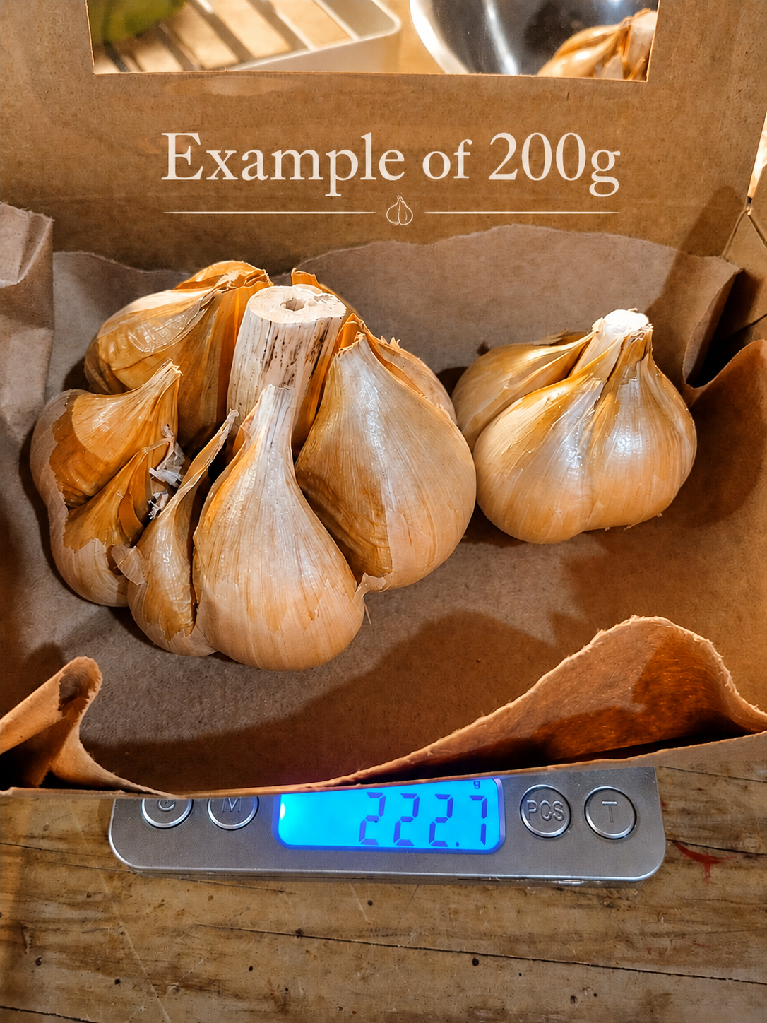 Garlic bulbs on a digital scale with a label indicating 200g weight.